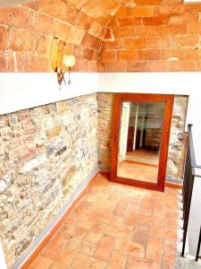a room with a stone wall and a mirror at Casa del Sole in Gambassi Terme