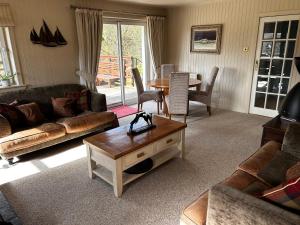 a living room with a couch and a table at Stunning country home with private wellness Spa in Strachur