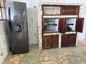 a kitchen with a refrigerator and an open cabinet at Del Mar Beach House in Nimá