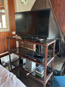 a tv on a glass table with a television at Le Chalet de Marie France in Combs-la-Ville