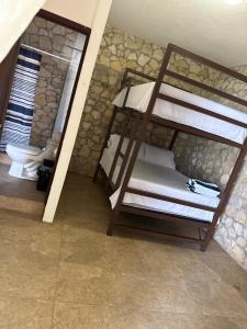 a room with two bunk beds and a toilet at Del Mar Beach House in Nimá