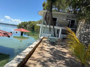 a house on the water with a table and chairs at Del Mar Beach House in Nimá