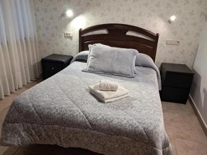 a bedroom with a bed with two towels on it at La orilla del sella in Cangas de Onís