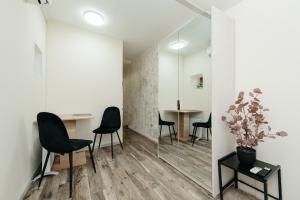 a room with black chairs and a table with a plant at Studio Room Central in Chişinău