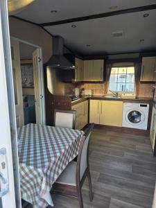 a small kitchen with a table and a table and chairs at Westwood Hide Away in Allhallows +6 photos