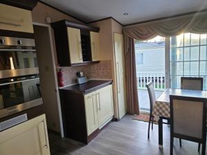 a kitchen and dining room with a table and a window at Westwood Hide Away in Allhallows