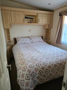 a bedroom with a large bed with wooden cabinets at Westwood Hide Away in Allhallows