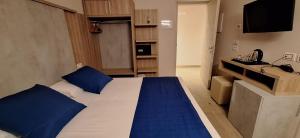 a bedroom with a large bed with blue pillows at Hotel Danieli La Castellana lago di Garda in Brenzone sul Garda