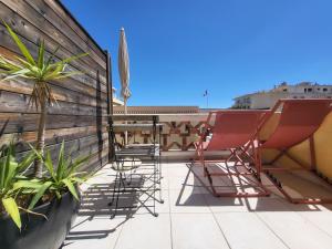 a patio with chairs and plants on a roof at Hôtel L'Oustaou in Le Lavandou