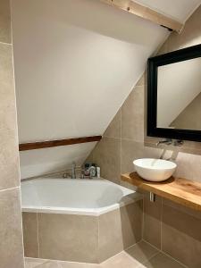 a bathroom with a bath tub and a sink at Private attic room with workspace & water view in Haarlem