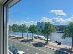 a view of a river with a boat in the water at Private attic room with workspace & water view in Haarlem