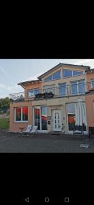 a large house with two umbrellas in front of it at Zimmer zum übernachten wg in Münsingen