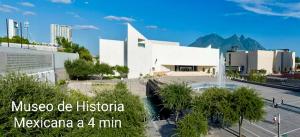 a large white building in a city with trees at Depa Loft Monterrey cerca de Fundidora, Macroplaza y Barrio Antiguo in Monterrey