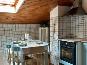a kitchen with a table with a white table cloth and a stove at Saleto Apartma in Jagodje