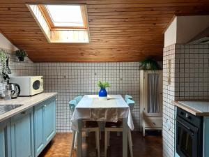 a kitchen with a table with chairs and a window at Saleto Apartma in Jagodje