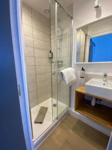a bathroom with a shower and a sink at Hôtel L'Oustaou in Le Lavandou