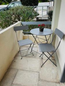 a table and two chairs sitting on a balcony at Sophia's studio in Saronida