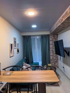 a living room with a table and a television at Apartamento elegante en el Centro in Cocorná