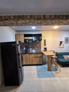 a kitchen with a black refrigerator and a table at Apartamento elegante en el Centro in Cocorná