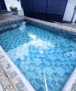 a swimming pool with blue tiles in the water at Royal Attitude in Port Mathurin