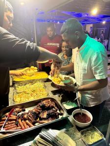 a group of people preparing food at a buffet at Royal Attitude in Port Mathurin