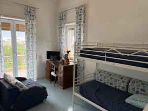 a bedroom with bunk beds and a desk with a computer at Villa due rami in Anacapri
