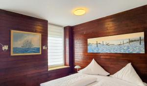 a bedroom with a bed and a picture on the wall at Hotel Münchner Löwenbräu in Cuxhaven