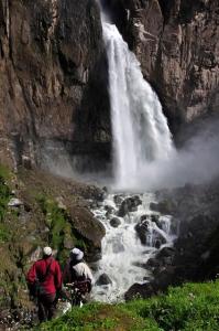 two people standing in front of a waterfall at Fure Wassi Hostel in Cabanaconde