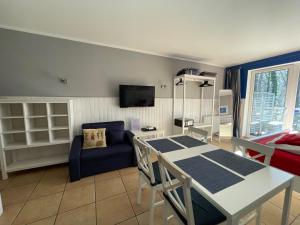 a living room with a table and a blue couch at Villa Park & Plaża in Świnoujście