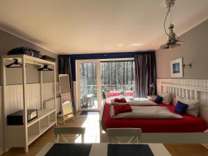 a bedroom with a red bed and a large window at Villa Park & Plaża in Świnoujście