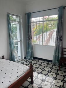 a bedroom with a bed and two large windows at Amour Coco Stay in Chaki Chaki +7 photos