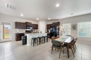 a large kitchen with a table and chairs and a counter at Stylish 4BR Escape Open Layout TVs in Every Room in El Paso +29 photos