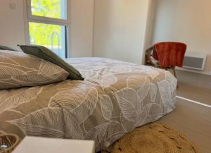 a bed in a room with a chair and a window at Studio confortable central in La Roche-sur-Yon