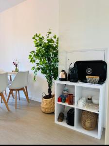a white shelf with a plant and a table at Studio confortable central in La Roche-sur-Yon