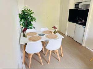 a white table with white chairs and a white kitchen at Studio confortable central in La Roche-sur-Yon +7 photos