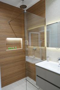 a bathroom with a glass shower and a sink at Arial Trinity Suites in Vlorë +175 photos