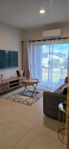 a living room with a couch and a table and a tv at Minnestayairbnb in Gaborone