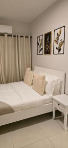 a bedroom with a bed with white sheets and pillows at Minnestayairbnb in Gaborone +5 photos