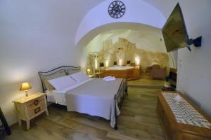 a bedroom with a bed in a room with a stone wall at Suite Grotta della luna - Romantic Luxury Jacuzzi in Ostuni