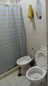 a bathroom with a toilet and a shower curtain at Dptos Edu in Malargüe