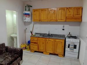 a kitchen with wooden cabinets and a stove at Dptos Edu in Malargüe