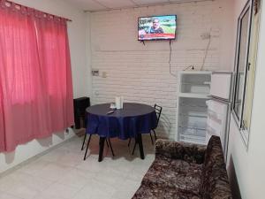 a room with a table and a tv on a wall at Dptos Edu in Malargüe