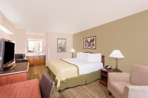 une chambre d'hôtel avec un lit et une télévision dans l'établissement Baymont by Wyndham Albany at Albany Mall, à Albany