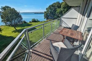 a balcony with a table and chairs and a view of the water at Junior-Suite Relaxe am See in Ascheberg