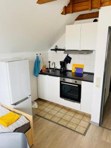 a small kitchen with white cabinets and a sink at Monteur Apartment Lingen Zentrum in Lingen