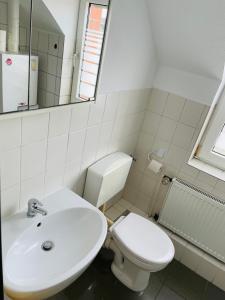 a white bathroom with a toilet and a sink at Monteur Apartment Lingen Zentrum in Lingen