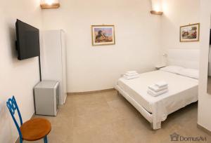 a small bedroom with a bed and a chair at Domus Avi - Bed and Breakfast in Taviano