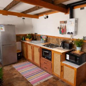 a kitchen with wooden cabinets and a stainless steel refrigerator at Casa Hortencia in Coñaripe