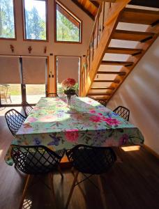 a dining room table with a vase of flowers on it at Casa Hortencia in Coñaripe +2 photos