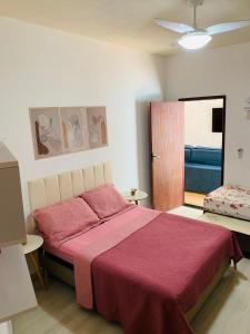 a bedroom with a large bed with a red blanket at Jesaluguel-de-casa in Cabo Frio +34 photos